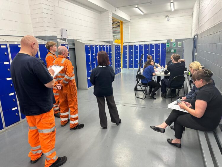 people waiting for blood pressure check in work depot