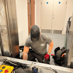 Lift engineer checking over a lift door operator.