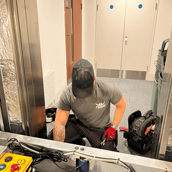 Lift engineer checking over a lift door operator.