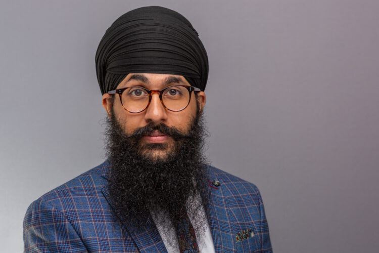 A business headshot of man wearing turban