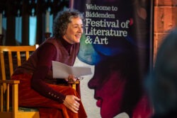 An author leans forward to engage with the audience during a reading