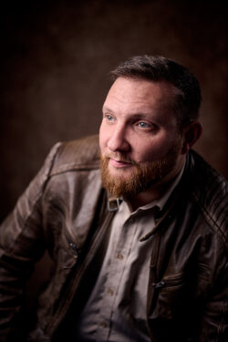 Portrait of man with brown jacket and grey shirt
