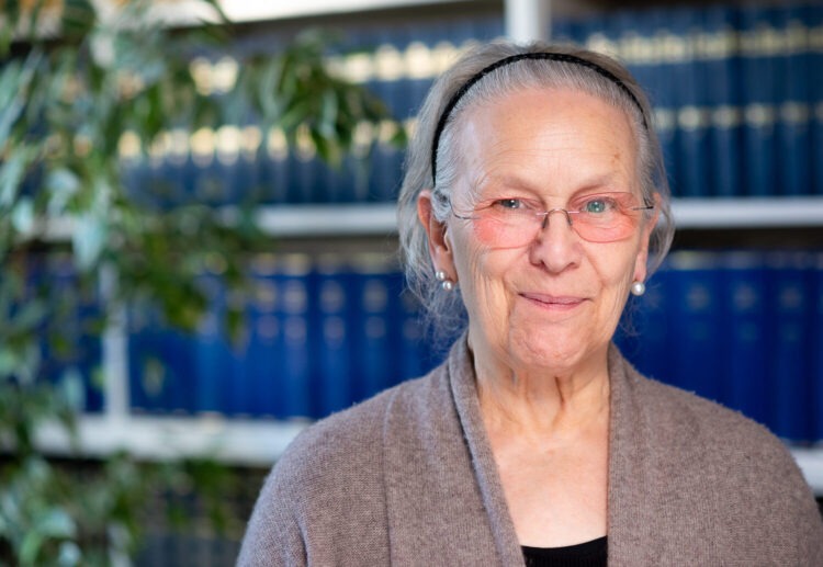 Corporate headshot of woman smiling at the camera with coloured glasses