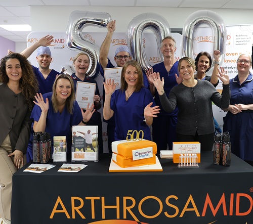 A group of hospital staff celebrating with balloons and cake