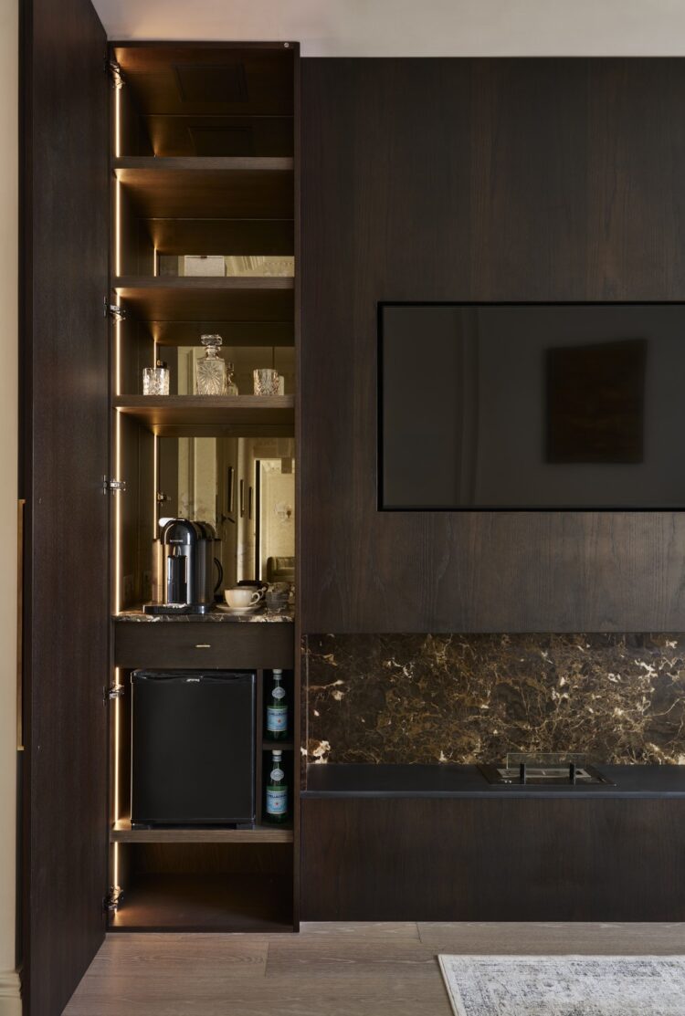 Bespoke fitted cabinetry with illuminated oak shelving and dark painted cupboards, manufactured by Collins Bespoke for a London home.