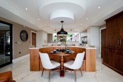 Luxury bespoke kitchen featuring a central island, walnut cabinetry and contemporary pendant lighting, designed and manufactured by Collins Bespoke in Kent.